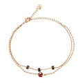 Gold-plated double chain bracelet featuring a red evil eye charm and black bead detailing