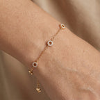 18k gold bracelet with diamond accents on a wrist against a neutral background