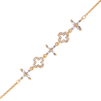 Gold bracelet with clover and floral designs on a white background