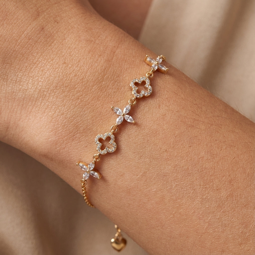 Gold bracelet with clover and floral designs on hand