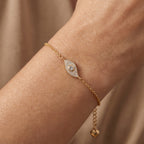 18k Gold bracelet with a diamond on a wrist against a neutral background
