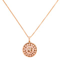 Gold-plated necklace with a round pendant featuring an Om symbol and clear stones on a white background