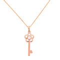 Gold-plated key pendant necklace with a floral detail on a white background