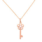 Gold-plated key pendant necklace with a floral detail on a white background
