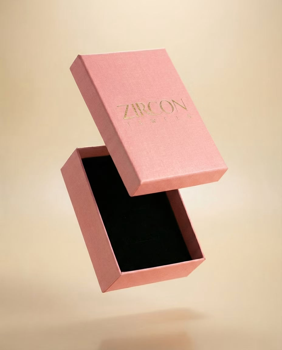Pink jewelry box with 'Zircon' branding on a beige background